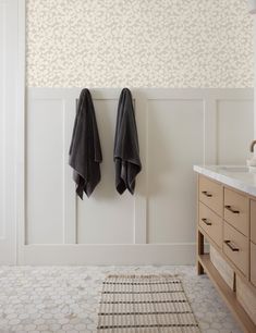 two black towels hanging on the wall in a bathroom