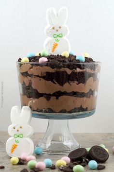 an easter cake with chocolate frosting and bunny ears on top, surrounded by candy candies