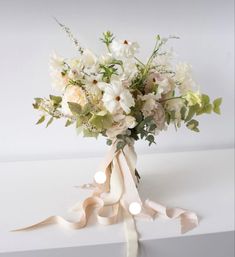 a bouquet of white flowers tied to a ribbon