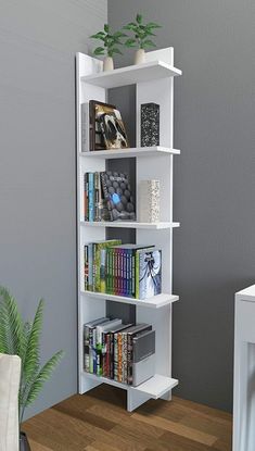 a white book shelf filled with books on top of a wooden floor next to a plant