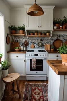 a white stove top oven sitting inside of a kitchen next to a wooden table and potted plants