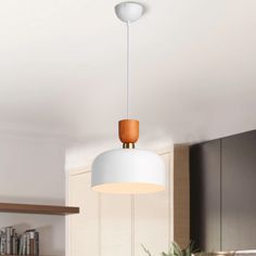 a white light hanging from the ceiling in a kitchen