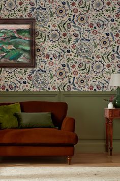 a living room scene with focus on the chair and wall papered in floral designs