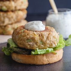 a chicken burger with lettuce and ranch dressing