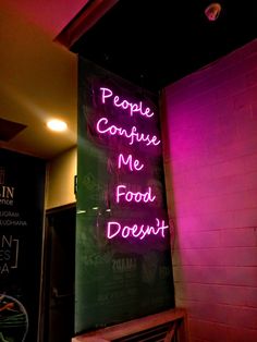 a neon sign that says people confue me food doesn't on the wall