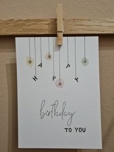 a birthday card hanging on a clothes line with the words happy birthday to you written in cursive letters