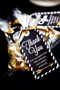 a black and white thank you tag with gold foiled candies in front of it