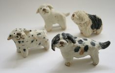 four small figurines of black and white dogs