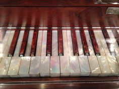 an old piano with marble tiles on it's keys and wood grained edges