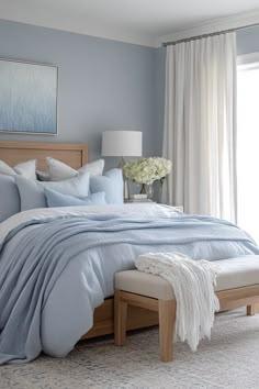 a bedroom with blue walls and white curtains