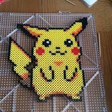 a close up of a piece of art made out of perler beads with a pikachu on it