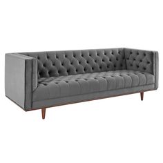 a gray couch with wooden legs and tufted upholstered back, on an isolated white background