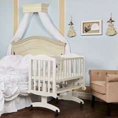 a baby's room with a crib, chair and pictures on the wall