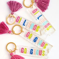 three plastic key chains with tassels and the words girls boss gorgeous on them