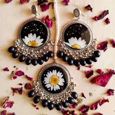 a pair of black and white earrings with flowers in the center, surrounded by petals