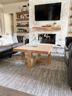 a living room with leather couches and a television mounted on the wall above a fireplace