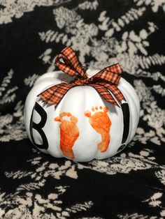 an orange and white pumpkin with handprints on it