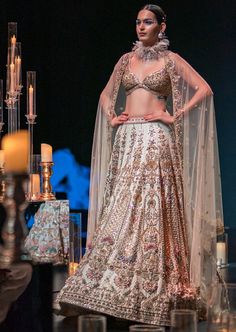 This enchanting earthy beige lehenga set is a beautiful blend of exuberance and grandeur. An ensemble that you will want this wedding season includes a lehenga, a blouse, a dupatta and a veil. Stitched to perfection, the lehenga features 3D embroideries with organza flowers using pearls, salli, cutdana, and stud tassels. The sleeveless blouse features a scintillating sweetheart neckline with handcrafted finish and a back hook closure. Paired with a heavy net dupatta, the cut-work detailing and intricate embroidery take center-stage. The lehenga comes with an attached cancan and the blouse has padding. Completed with a veil, this opulent ensemble silhouette will glimmer in the spotlight. Dry-clean only if required. Slight variation in color is possible due to digital photography. Intricate Embroidered Lehenga For Wedding Reception, Elegant Lehenga With Intricate Embroidery For Wedding Reception, Floor-length Lehenga With Intricate Embroidery For Wedding Reception, Festive Resham Embroidered Lehenga For Wedding Reception, Traditional Floor-length Lehenga For Wedding Reception, Festive Resham Embroidery Lehenga For Wedding Reception, Elegant Lehenga With Dupatta For Wedding Reception, Elegant Gown With Dupatta For Wedding Reception, Anarkali Floor-length Gown For Wedding Reception