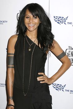 a woman with black hair and tattoos posing for the camera