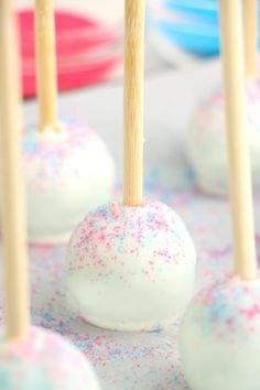 cake pops with sprinkles and wooden sticks sticking out of them on a table