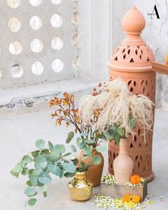 an assortment of vases and flowers on the ground