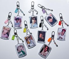 six keychains with pictures of people hanging from them on a white table top