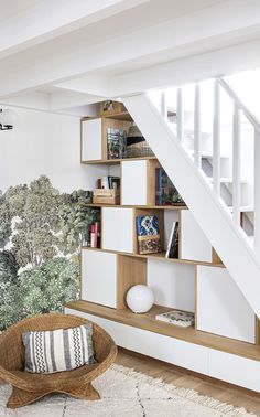 a living room filled with furniture and a stair case in front of a painting on the wall