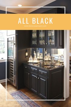 an all black kitchen with lots of counter space and glassware on the sink area