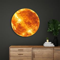 a large orange sun in the middle of a room with a plant on top of it