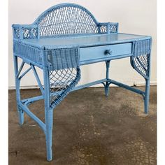 a blue wicker desk with two drawers