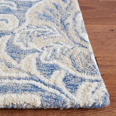 a blue and white area rug on a wooden floor with a wood floor in the background