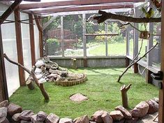 the inside of a greenhouse with grass and rocks