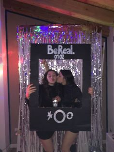 two women standing next to each other in front of a mirror with the words booreal one on it