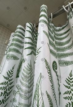 green and white curtains hanging from a metal rod