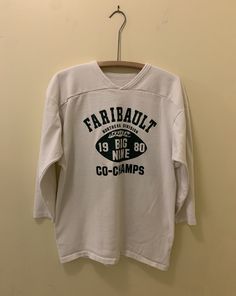 a t - shirt hanging on a wall that says fairbailt in black and white