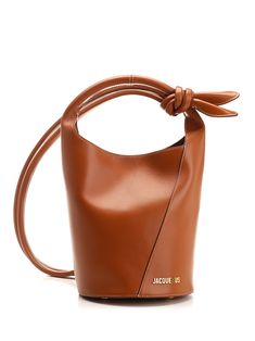 "Le Petit Tourni" mini bucket bag from Jacquemus, in brown leather with knotted detail, snap button closure, shoulder strap tied on the side, internal zip pocket. Cognac Bucket Bag For Evening, Everyday Leather Shoulder Bag With Loop Closure, Evening Cognac Bucket Shoulder Bag, Brown Leather Handle Bucket Bag For Evening, Evening Brown Bucket Bag With Leather Lining, Evening Brown Bucket Bag With Leather Handles, Cognac Evening Bucket Bag, Evening Cognac Bucket Bag, Brown Leather Handled Evening Bucket Bag