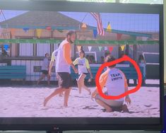 a tv screen with people playing volleyball on the beach