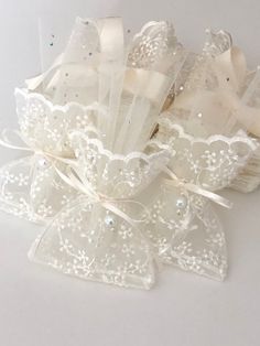 three white wedding garters with bows and lace on them, sitting next to each other