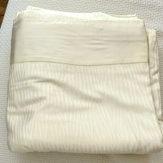 an unmade bed with white sheets and pillows