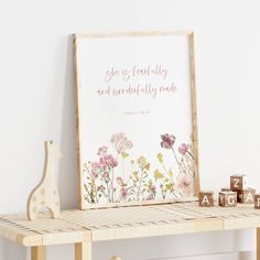 a wooden shelf with a sign and toy animals on it next to a white wall