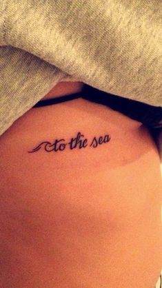 a woman's stomach with the words to the sea tattooed on her lower back