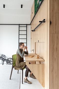 a man sitting at a desk in front of a wooden shelf with shelves on it