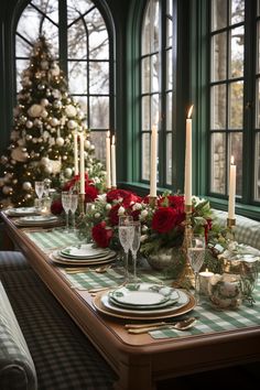 a table set for christmas with candles and plates