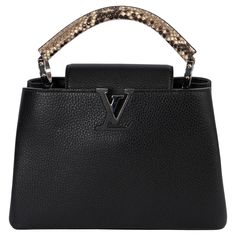 100% authentic Louis Vuitton Capucines MM bag in black full-grain Taurillon leather, it features a distinctive flap which can be worn two ways: outside to reveal a Monogram Flower, or inside to display the leather-wrapped LV Initials. This elevated model has a top handle made from luxe ayers skin, which gives the design a sophisticated touch. Silver-tone hardware Magnolia and snap hook closure in the middle. Compartmented interior with zipped pocket against the back and lined in red smooth cowhide-leather. Detachable shoulder-strap is missing. Has been carried and is in excellent condition. Shoulder-strap is missing. Measurements Model N92800 Height 20cm (7.8in) Width 31cm (12.1in) Depth 11cm (4.3in) Hardware Silver-Tone All our listings include only the listed item unless otherwise specif Luxury Designer Caviar Leather Bags, Designer Top Handle Bag For Everyday Luxury, Designer Everyday Luxury Top Handle Bags, Designer Everyday Luxury Bag With Handles, Luxury Shopping Bags With Round Handle, Luxury Shopping Bag With Round Handle, Designer Handheld Bags For Everyday Luxury, Luxury Bags With Gold-tone Hardware And Round Handle, Luxury Shopping Satchel With Round Handle