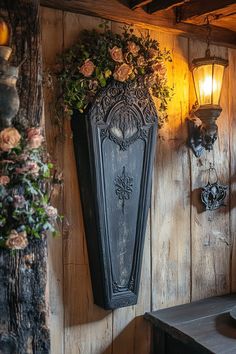 a wooden wall with flowers hanging from it's side next to a table and lamp