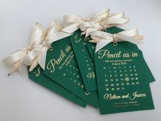 four green wedding cards with white ribbons tied around them