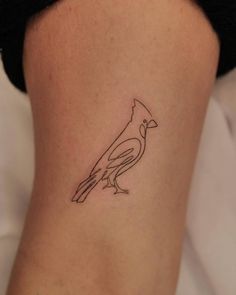 a small bird tattoo on the back of a woman's thigh