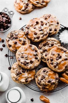 chocolate chip cookies on a cooling rack with salt and milk in the background, along with other desserts