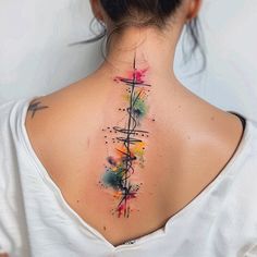 the back of a woman's neck is covered in colorful ink and has a cross tattoo on it