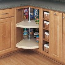 a corner cabinet in a kitchen filled with lots of cupboard space and food items on the shelves